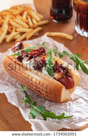 Homemade hot dog with suluguni cheese, bacon and arugula