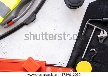 a set of necessary for the car warning sign, first aid kit, reflective vest, metal hook, part of the Jack device, wrench, hexagon and flavor in the form of a smile and a wiper blade