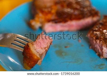 Pictures  of a sliced fresh rump steak with fat on the steak on a plate and a fork