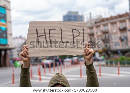 Victim in need of help. request for support. sacrifice. Social public messages on banners outside on streets. problems reflection phrases . Man holding conceptual sign. Guy with sign inspiration
