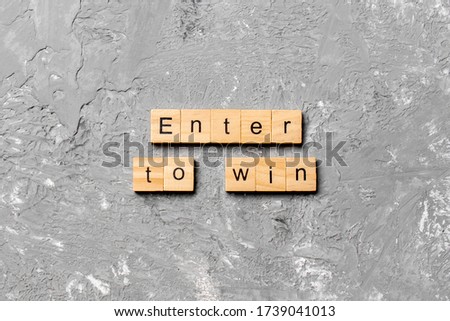 Enter To Win word written on wood block. Enter To Win text on cement table for your desing, concept.