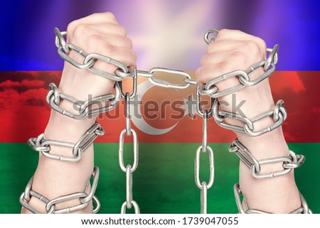 Two hands shackled a metal chain on Azerbaijan flag. Freedom concept
