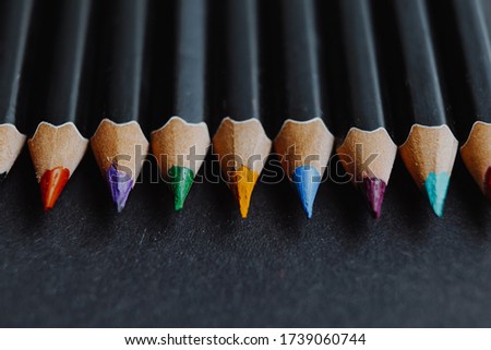 dark creative artistic background with sharpened colored pencils. Background for art workshops, artists' workshops, picture galleries, art schools or social advertising