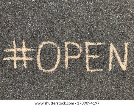Hashtag open hand drawn on the asphalt with sidewalk chalk, #open, concept of we are open, reopen after lockdown