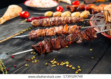 Side view on four different caucasian shashlyk skewers beef, mutton, lulya and mushroom on the wooden table, horizontal