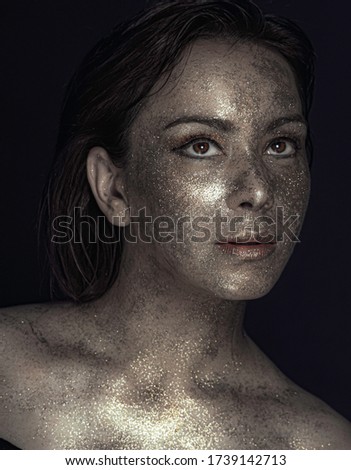 Portrait of a model girl with shiny makeup, with shiny pigmented skin and beautiful facial features
