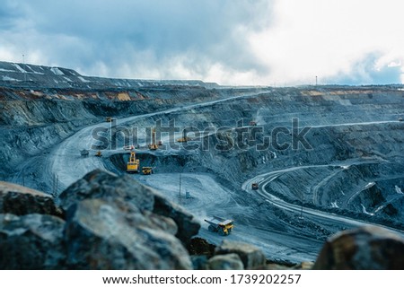 Work of trucks and the excavator in an open pit on gold mining Royalty-Free Stock Photo #1739202257