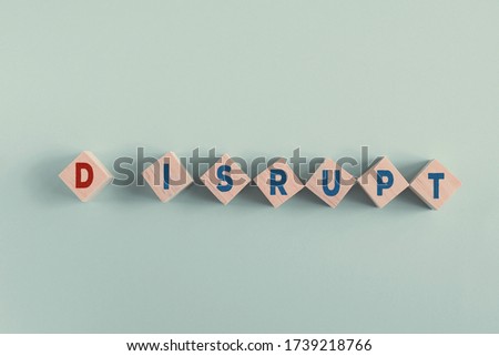 wooden blocks with word DISRUPT, disruptive innovation way of business concept 