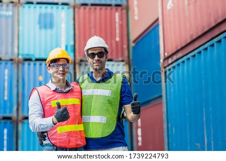 Staff and foreman control loading container cargo working team happy enjoy working standing smile hand show thumbs up.