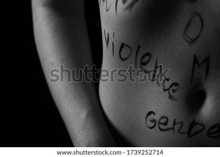 part of the body of a young girl with the inscription violence . the captions are written in the photographer's hand, not in a tattoo . black and white photo.