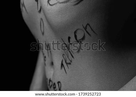 part of the body of a young girl with the inscription treason . the captions are written in the photographer's hand, not in a tattoo . black and white photo.