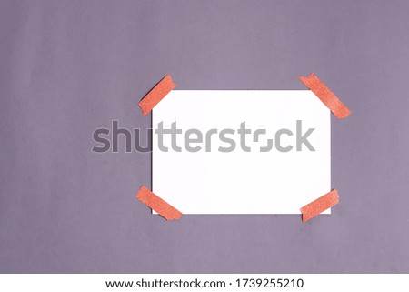 Blank paper frame glued with adhesive tape to light gray backgrround as template for graphic designers presentations, portfolios etc.
