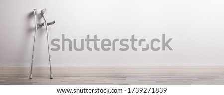 Two Crutches Leaning On Wall In Clinic Royalty-Free Stock Photo #1739271839