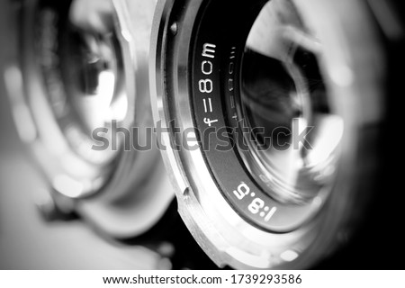 Vintage twin reflex camera lens with shallow depth of field in black and white. Retro style medium format camera lens in blur. Vintage film camera lens.