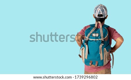 Asian man in casual t-shirt wearing and cap with backpacker ready to travel for his holidays isolated on blue background with copy space. clipping paths.