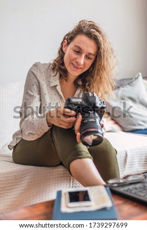 Smiling female photographer edits her photographs at home.