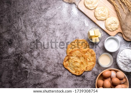 Roti pictures of Indian and Muslim food. And various ingredients such as eggs, flour, sugar, butter, sweet milk, and cooking tools are all on the old table, with copy space.