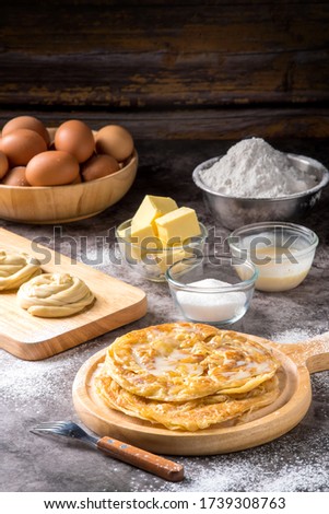 Roti pictures of Indian and Muslim food. And various ingredients such as eggs, flour, sugar, butter, sweet milk, and cooking tools are all on the old table.