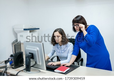 The boss checks the task from the office employee on the computer