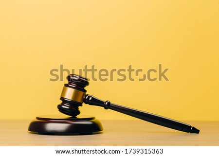 Judge Gavel on a wooden table and yellow-orange background. The concept of law. sentence, justice