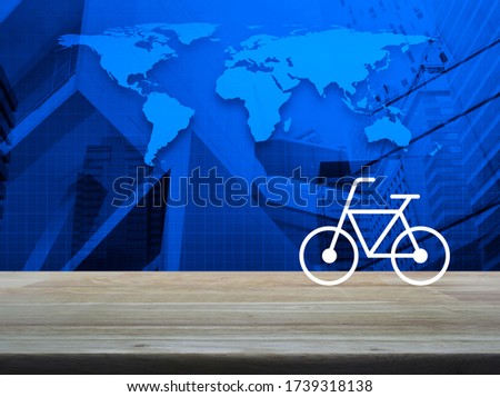 Bicycle flat icon on wooden table over world map, modern city tower and skyscraper, Business bicycle shop online concept, Elements of this image furnished by NASA