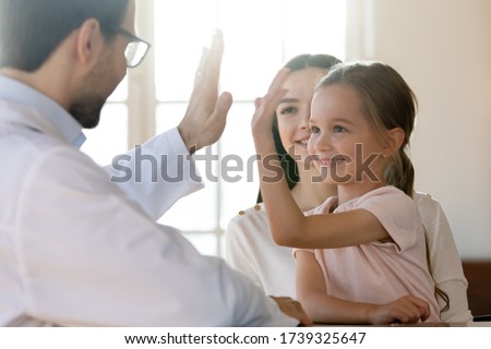 Little girl child give high five to positive male doctor or GP at consultation with mom, small kid make deal celebrate good medical checkup or greeting with smiling pediatrician at meeting in hospital Royalty-Free Stock Photo #1739325647
