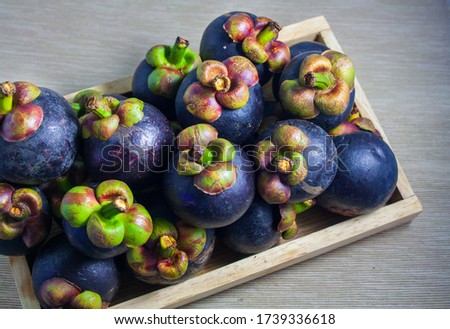 Mangosteens group in wooden tray