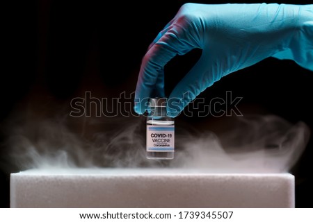 Doctor's hand holding bottle vaccine Covid-19 from storage box. Medication treatment concept. Royalty-Free Stock Photo #1739345507