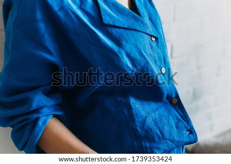 Girl in pajamas in a blue shirt made of linen, beautiful home clothes. Cozy bathrobe. Natural fabric. Homewear