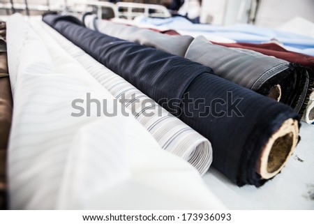 fabrics of different colors in rolls on a table 