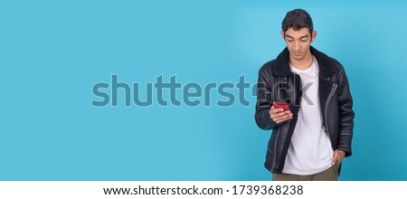 young male with mobile phone isolated on color background
