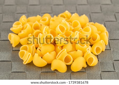 The heap of pasta on the gray bamboo place mat.