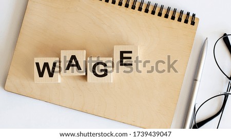 Concept wooden blocks Wage on a wooden notepad