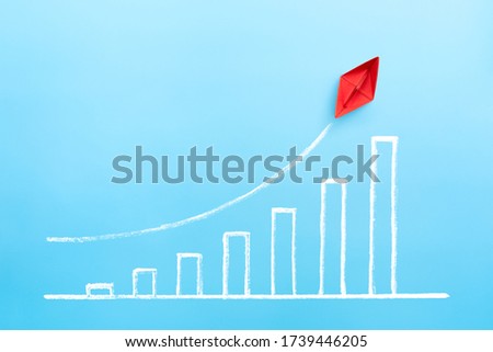 Red paper ship with growing a sketch graph on blue background, Growth and successful concept.