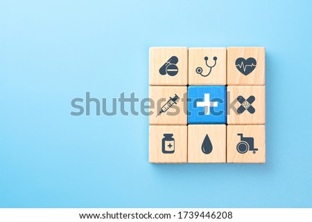 Health insurance concept, wooden blocks with healthcare medical icons on blue background, copy space