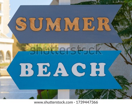 Wooden summer and beach arrow sign on the street