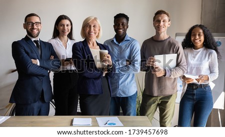 Smiling diverse employees posing for corporate portrait in office together, happy successful business team looking at camera, mature female executive with staff standing in modern office Royalty-Free Stock Photo #1739457698