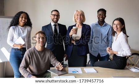 Successful diverse employees with team leader looking at camera, posing for corporate portrait in modern boardroom together, satisfied business people colleagues with boss standing in office Royalty-Free Stock Photo #1739457716