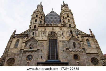 cathedral church medieval architecture building huge facade front side foreshortening from below on gray cloudy sky background in Vienna capital of Austria  
