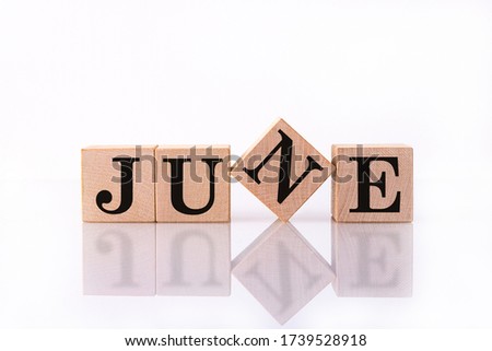 The word June on wooden cubes. Concept Month of year.