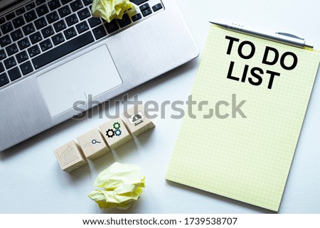 Notepad and laptop on wood table.TO DO LIST text