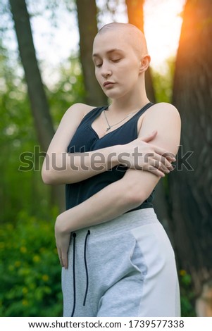 bald girl posing in nature on a green background