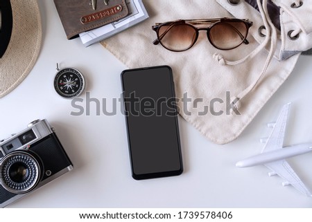 Empty screen smart phone with travel accessories and items on white background with copy space, Travel planning concept