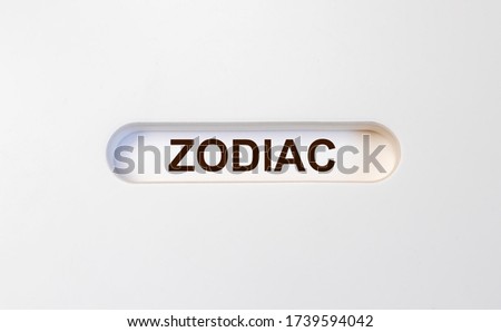 text word inscription Zodiac concept and theme in hole of a white background