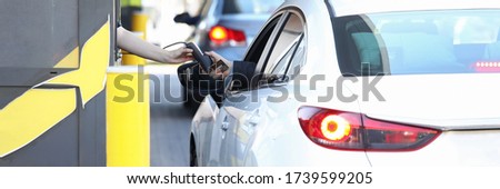 Convenient payment from car, drive thru system. Payment for services credit card using pos terminal. Customer purchases goods without leaving his car. Drivers are charged certain fare. Royalty-Free Stock Photo #1739599205