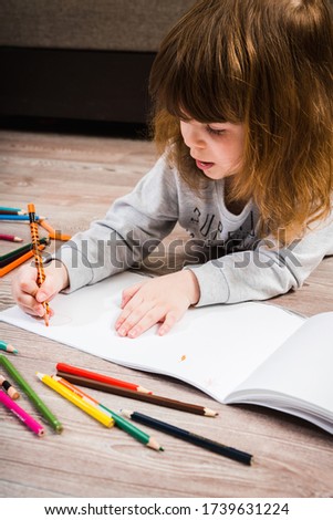Little girl drawing with pecils. Selective focus. Shallow depth of field.