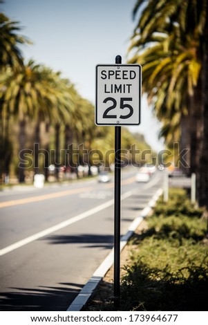 Speed Limit 25 sign on the road with palms, USA
