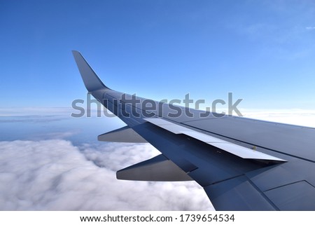 Aircraft spoilers lifting before landing. Aerial view of airplane wing with blue sky and clouds. Preparation for landing. Royalty-Free Stock Photo #1739654534