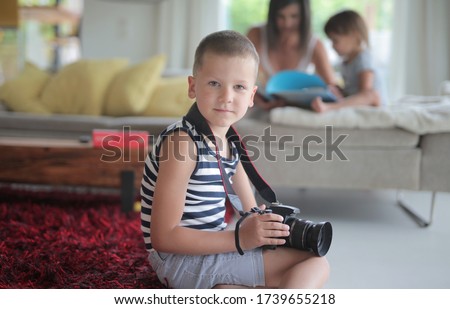 young boy with digital camera  at home