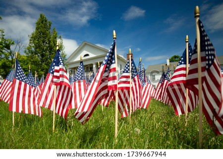 american flags on town hall grass blue sky
